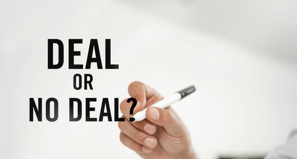 A person’s hand holding a black and white marker pen appears next to bold black text on a white background that reads, “DEAL OR NO DEAL?”.