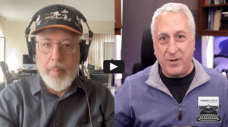 Two men are shown in a split-screen video call. The man on the left wears glasses, headphones, and a dark hat with a white beard. The man on the right wears a gray zip-up and speaks, with shelves visible behind him.