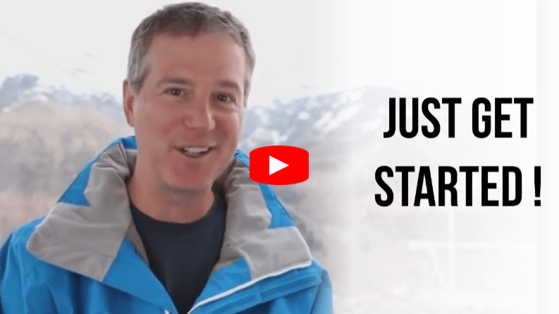 A smiling man in a blue jacket stands outdoors with mountains in the background. Next to him, bold text reads JUST GET STARTED! with a red YouTube play button icon in the center.