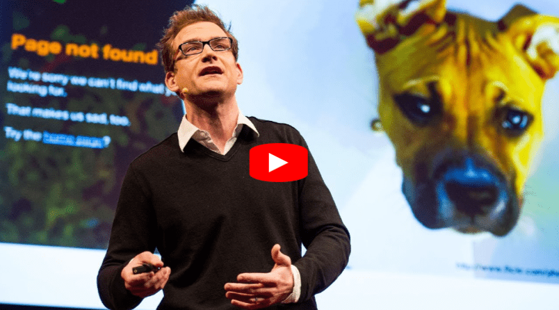 A man giving a presentation stands in front of a screen showing a Page not found error message with a sad dog image and text. The YouTube play button appears in the center of the image.
