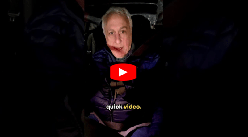 A man with gray hair sits in a dark car wearing a seatbelt and blue jacket. A play button is over his face, and the words “quick video.” appear in yellow and white text at the bottom.