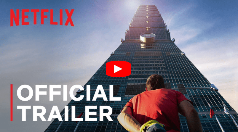 A person in a red shirt looks up at a tall skyscraper under a blue sky. The Netflix logo is at the top left, and āOfficial Trailerā is written in bold white letters at the bottom left with a YouTube play button overlay.
