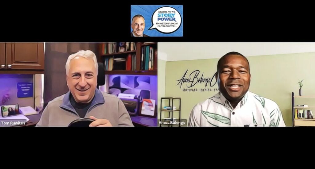 Two men, Tom Ruwitch and Ahmard Vital, are smiling and talking in a virtual interview. The background shows shelves, books, and a wall sign. Above, there’s a Story Power Marketing Show logo with Tom’s photo.