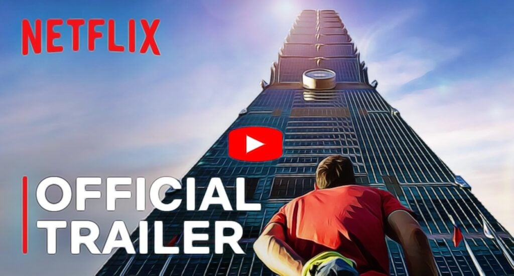 A person in a red shirt climbs a tall skyscraper under a blue sky. The words “NETFLIX” and “OFFICIAL TRAILER” appear, along with a red play button symbol at the center of the building.