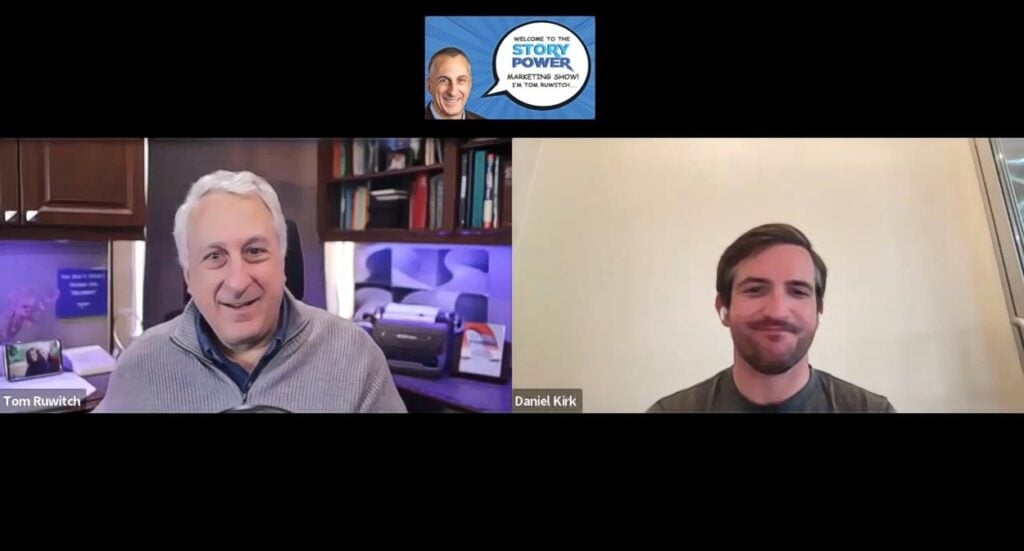 Two men, Tom Ruwitch and Daniel Kirk, appear on a split-screen video call for The Story Power Marketing Show. Tom is smiling in a cozy office, while Daniel is smiling in a plain, well-lit room.